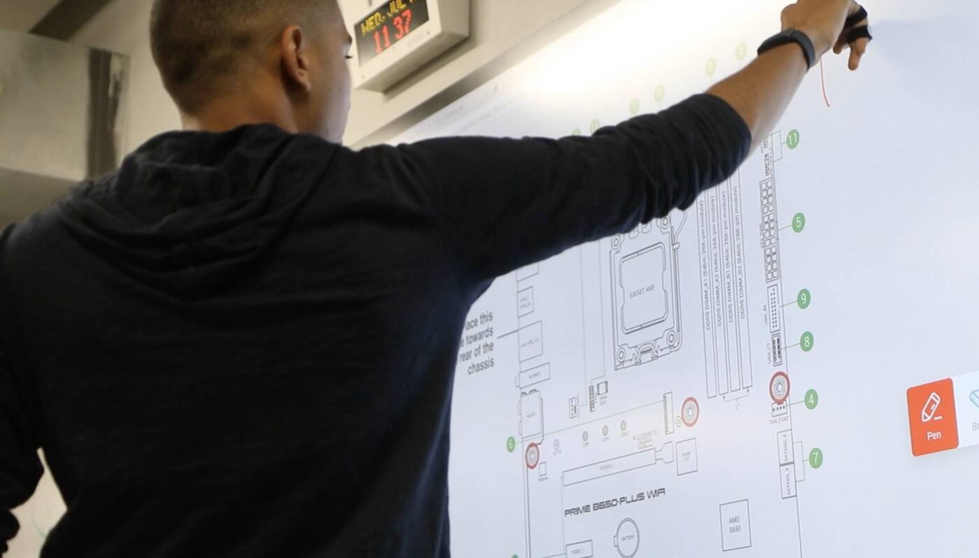 Instructor walking students through a motherboard diagram on a large screen